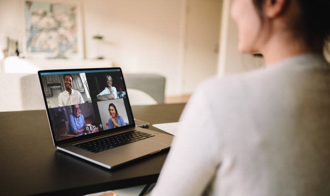 Woman using VOIP on her computer while looking at people she is talking to